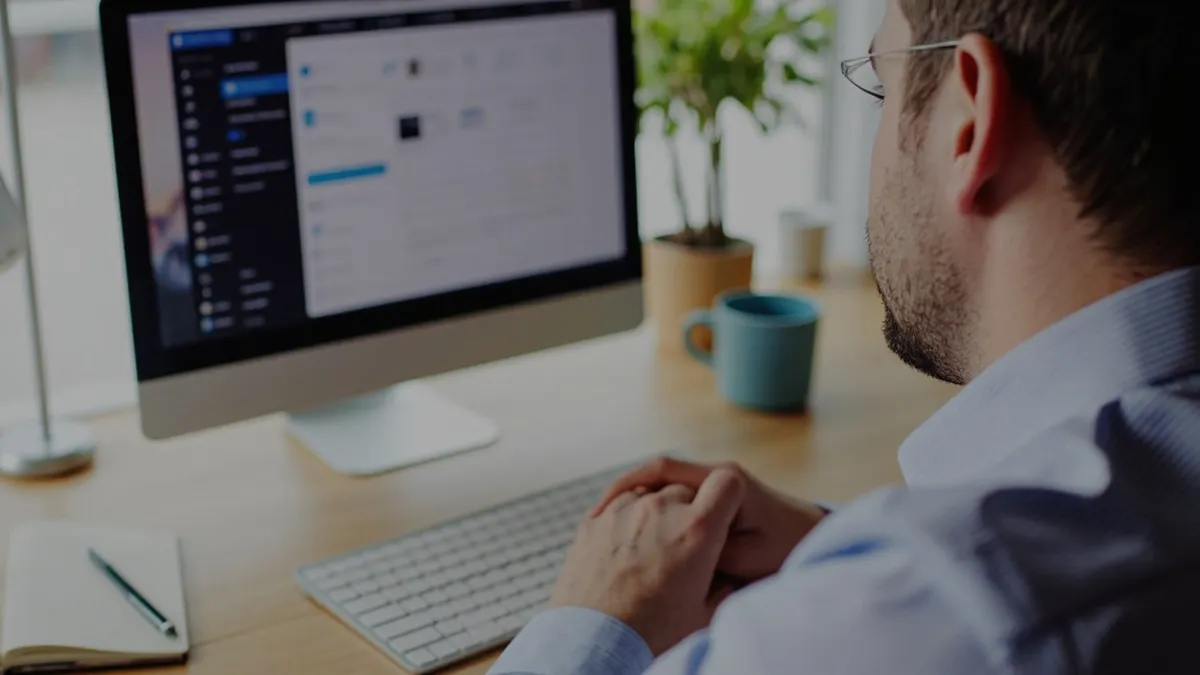 Retail business owner reviewing AI chatbot and email automation dashboards on a computer at a tidy desk.